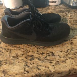 All black mesh Nike running shoes.